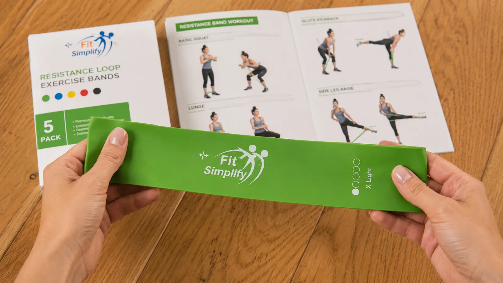 Hand holding a green Fit Simplify resistance loop band before a stretching session