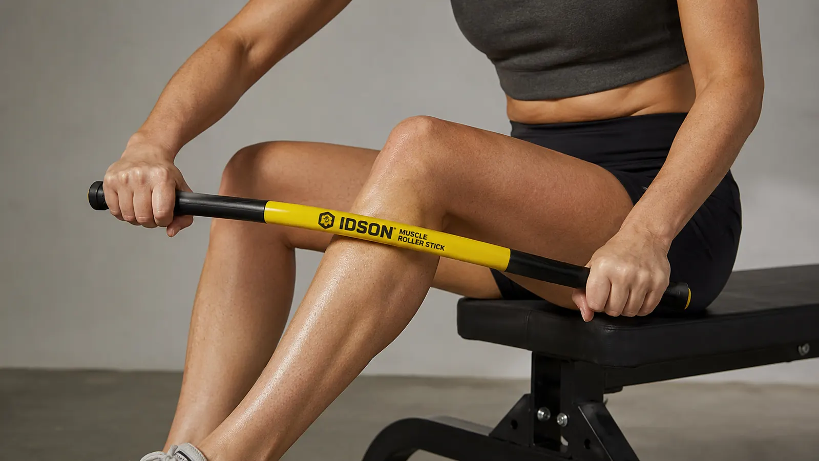Person pressing a muscle roller stick into a calf with visible stick flex bowing in the middle